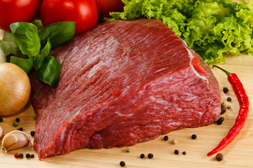 Raw beef on cutting board and vegetables