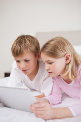 Portrait of cute children using a tablet computer