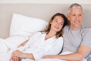 Fototapeta premium Happy couple lying on a bed