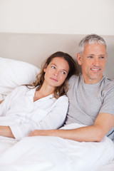 Fototapeta premium Portrait of a happy couple lying on a bed