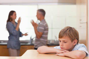 Sad little boy hearing his parents having am argument