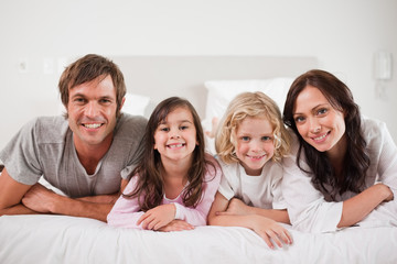 Cheerful family lying in a bed