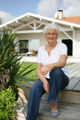 Elderly lady sat on decking