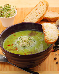 Bowl of peas soup garnished with shaved Parmesan cheese