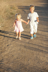 Fototapeta premium young brother and sister walking by country road