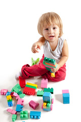 Smiling little boy playing with blocks