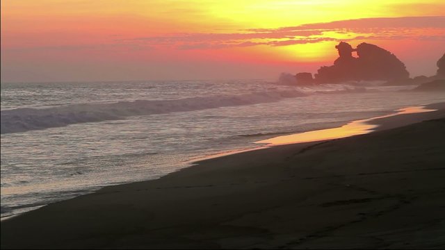 Man Walking on the beach during sunset