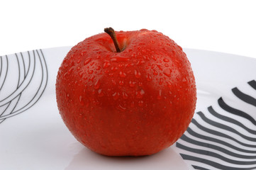 Red apple on a white dish