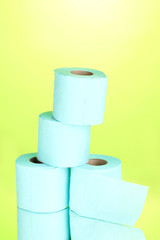 blue rolls of toilet paper on green background