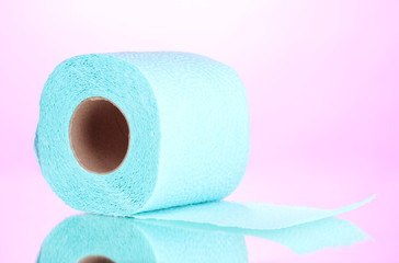 blue roll of toilet paper on pink background