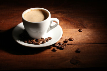 cup with coffee and coffee beans on  wooden table