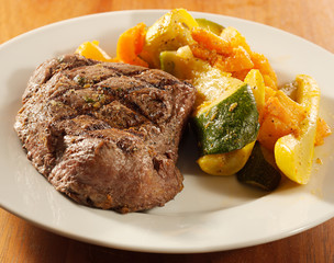 steak with grill marks and vegetables,