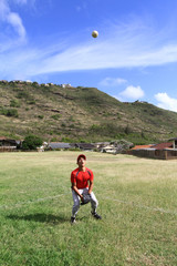 Outfielder watches a fly ball and prepares to catch it