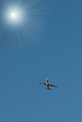 plane on background blue sky flies to sun