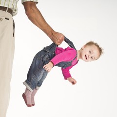 father holding baby toddler suspended by suspenders