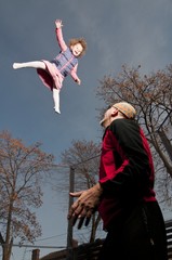 happy toddler girl jumping up on trampoline
