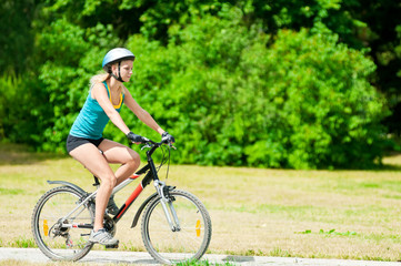 Fototapeta na wymiar Young smiling woman on bike