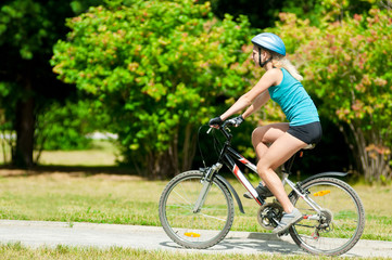 Fototapeta na wymiar Young smiling woman on bike