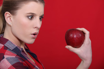 Shocked woman holding apple