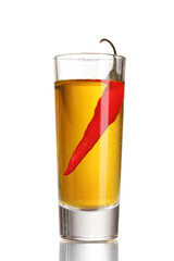 glass of pepper vodka and red chili pepper isolated on white