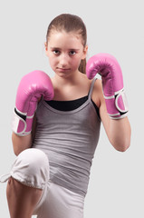 Portrait of pretty kick boxing girl with pink gloves exercising