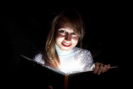 Young woman reading a magic book