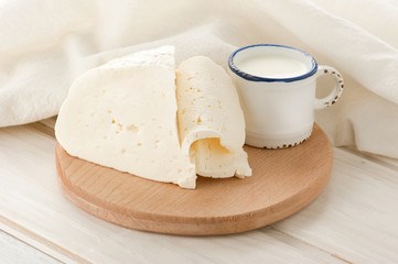 Breakfast with milk and soft sheep cheese on old wooden table