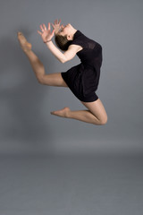 Girl jump over grey background. Studio shot