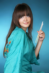 Young woman with chopsticks over green