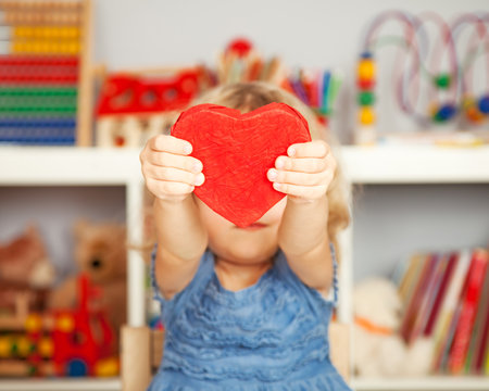 Happy child with red paper heart