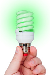 Energy saving lamp with green light in hand.