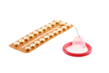 Birth Control Pills and a condom with a pinhole