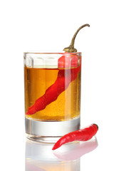 glass of pepper vodka and red chili peppers isolated on white