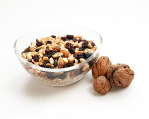Glass bowl with muesli and nuts isolated on white background.