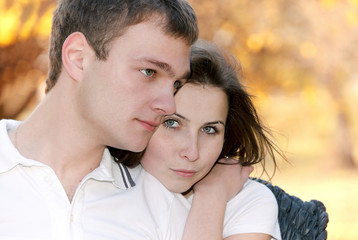 Obraz premium Closeup portrait of a cute young couple together with arms aroun