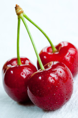 A close up of three ripe cherries