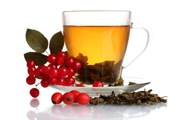Green tea  with red viburnum and  hips in glass cup isolated