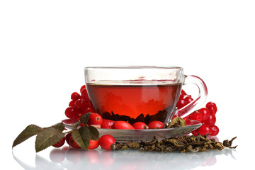 Black tea  with red viburnum and  hips in glass cup isolated