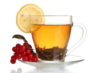 Green tea  with red viburnum and lemon in glass cup isolated