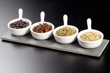 Row of assorted spices in white bowls