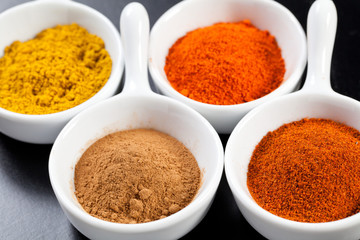 Assorted hot spices in white bowls