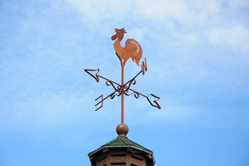Wind cock weather vane direction on blue sky