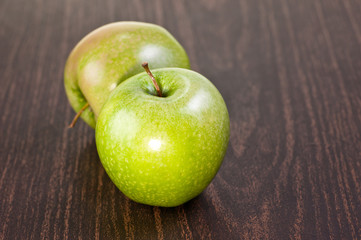 Two apples on a dark wooden table