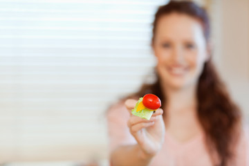 Mouthful of salad being offered by girl