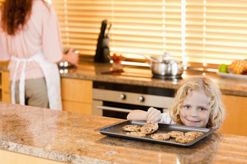 Boy stealing a cookie while his mother is not watching