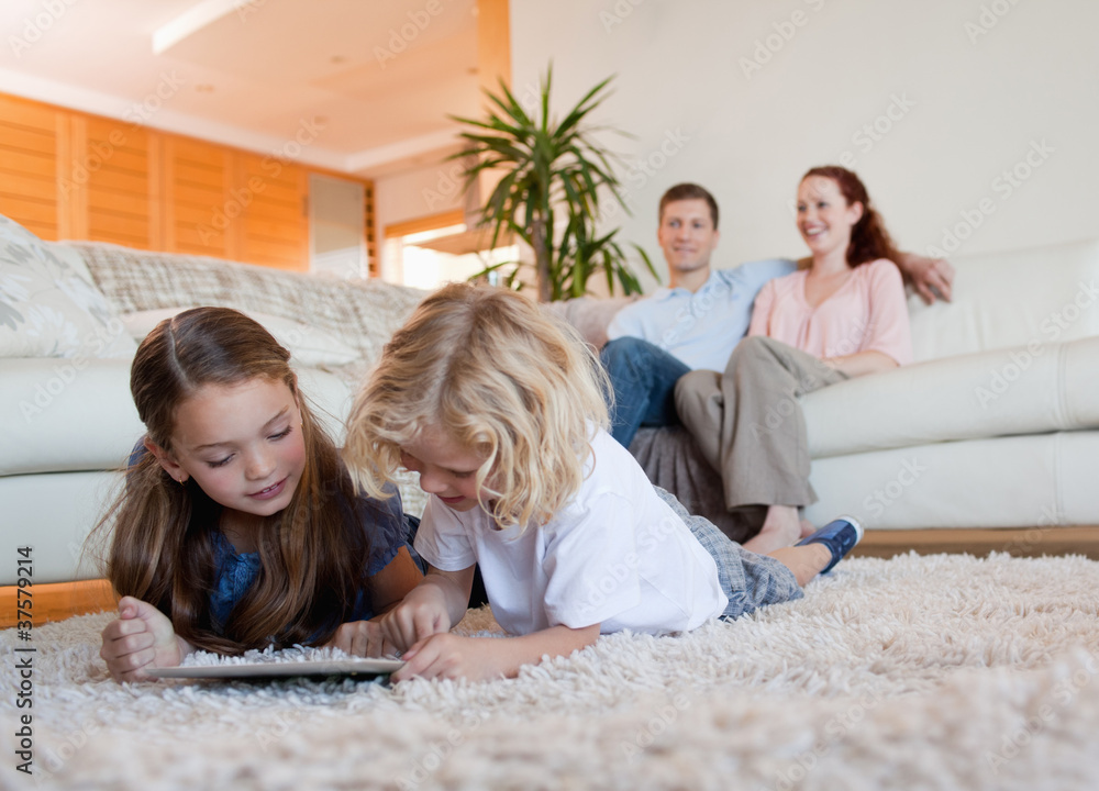 Poster children using tablet on the carpet