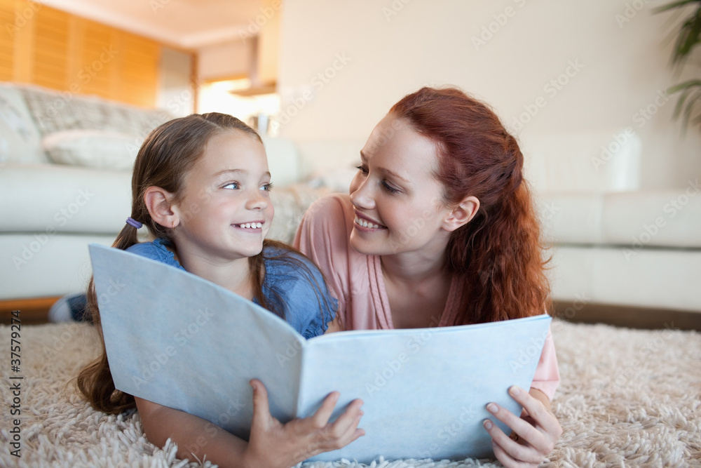 Wall mural mother and daughter with periodical on the floor