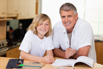 Obraz premium Man helping his son with homework
