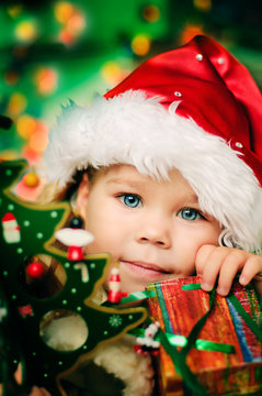 Happy small girl in santa hat with lot of gift have a christmas