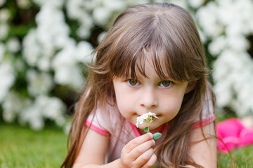 girl smells on a flower otudoor in grass